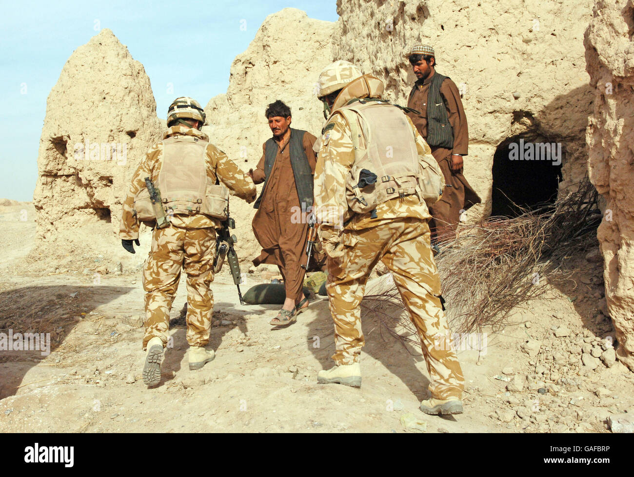 Local Police force officers meet Royal Marine Commando's near the village of Muktar which is near Lashkar Gah in the Helmand Province in Afghanistan as Royal Marine Commando's patrol the province. Stock Photo