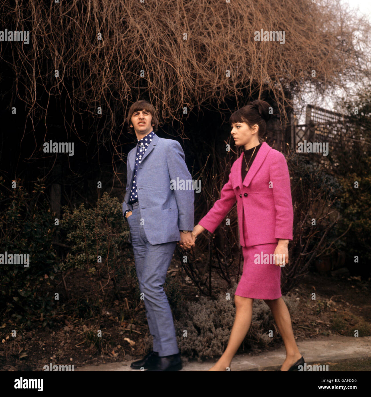 Strolling hand-in-hand are Ringo Starr, the Beatles drummer, and his bride, the former Maureen Cox. They are pictured in the garden of the house in Princes Crescent, Hove, Sussex, lent them by solicitor David Jacobs for a short honeymoon. The couple were married at an early morning ceremony at Caxton Hall register office, London. Stock Photo