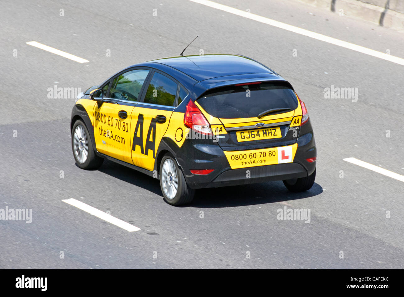 AA driving school Ford Fiesta instruction car with L plate driving along M25 English motorway Essex England UK Stock Photo