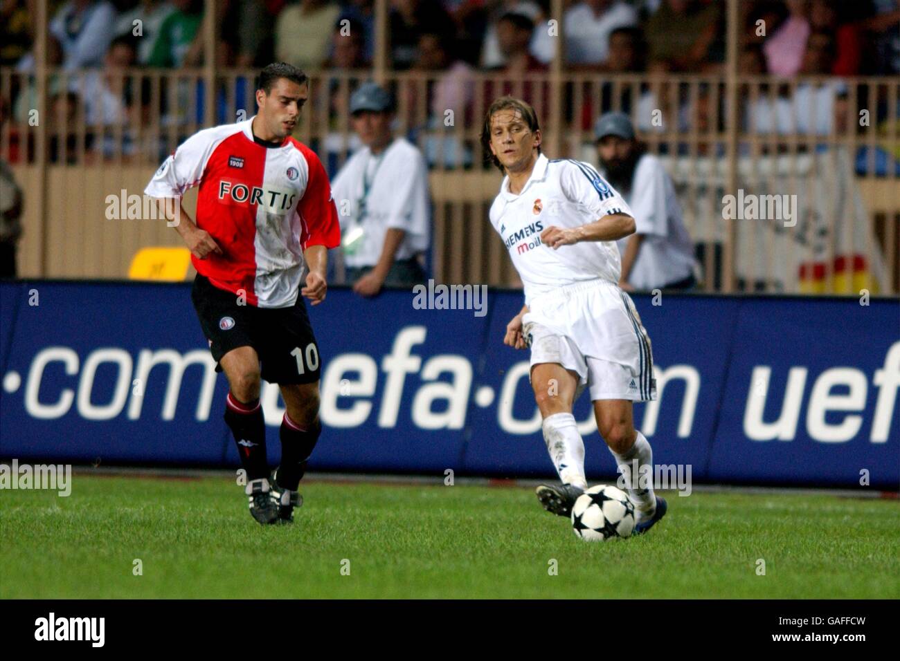 Real Madrid's Michel Salgado (r) passes the ball as he is closed down by Feyenoord's Anthony Lurling (l) Stock Photo