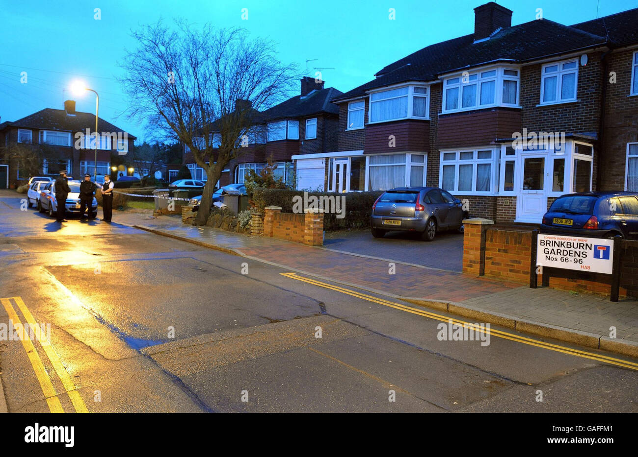 Police officers (left) at the scene in Wembley, north London, after a policeman died after he attended a 'domestic incident' in in Brinkburn Gardens, Wembley. Stock Photo
