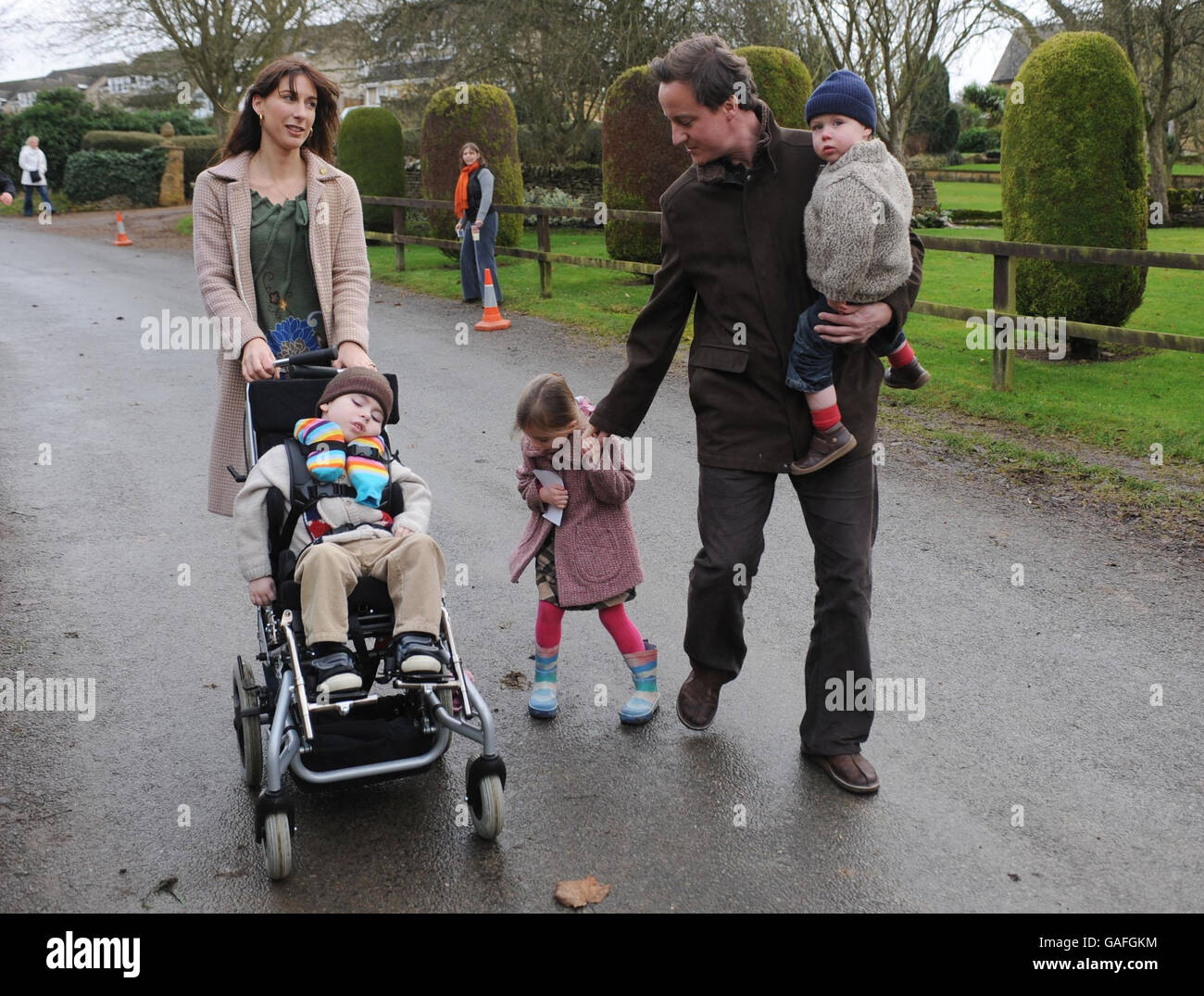 Conservative Party leader David Cameron walks through the village of Chadlington near his Oxfordshire home after officially starting the Chadlington 'fun run', with his wife Samantha and children from left Ivan, Nancy and Arthur Elwen. Stock Photo