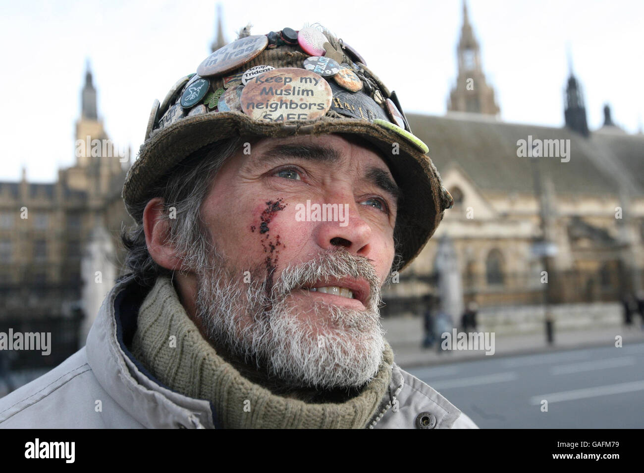 Peace campaigner Brian Haw, who was left with cuts to his face and wrist after being arrested outside Downing Street during a protest against the Serious Organised Crime and Police Act (Socpa), stands in front of the Houses of Parliament a day after he was allegedly assaulted by a police officer. Stock Photo