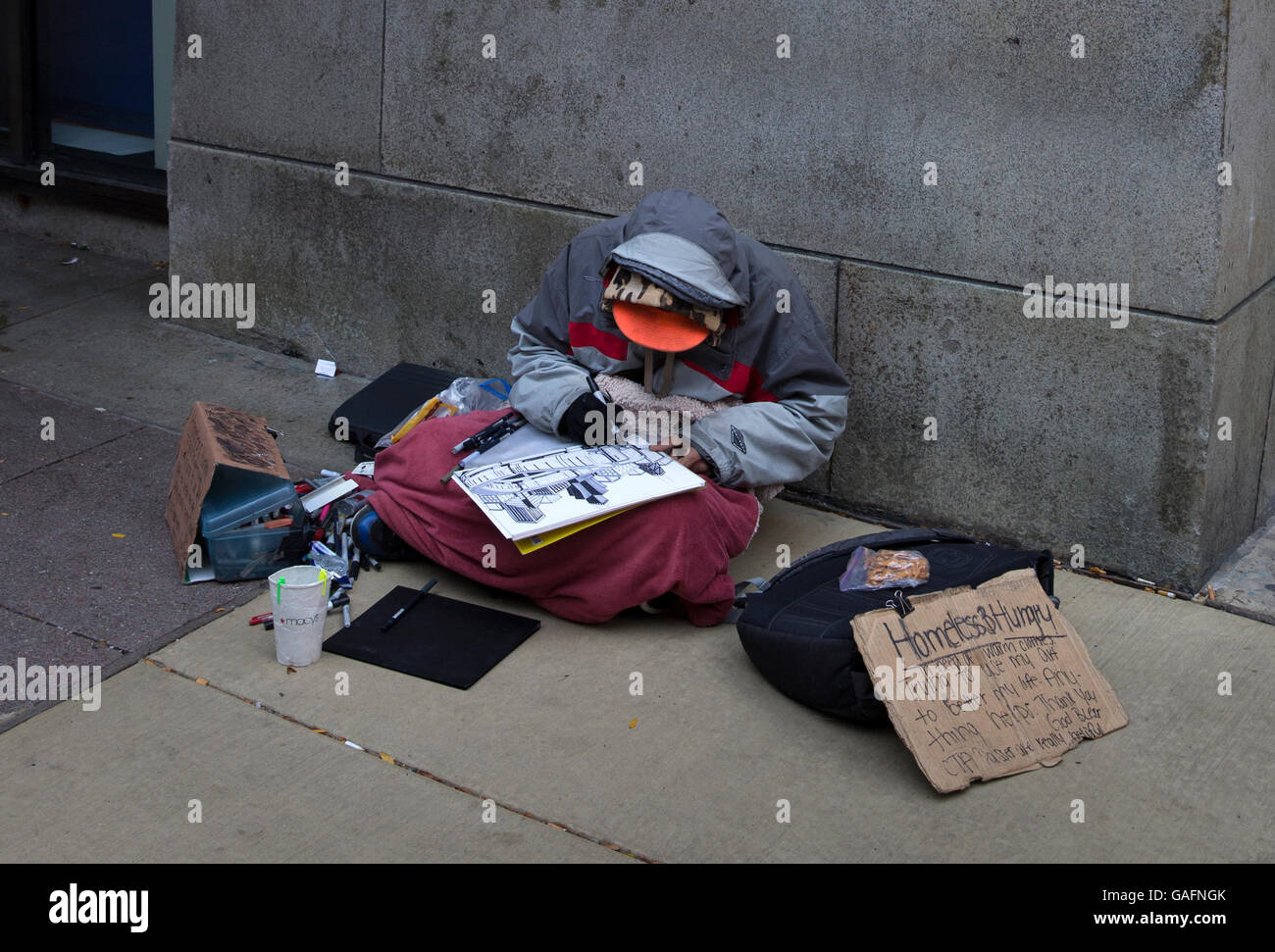 Homeless and hungry person making art for sale in downtown Chicago, Illinois Stock Photo