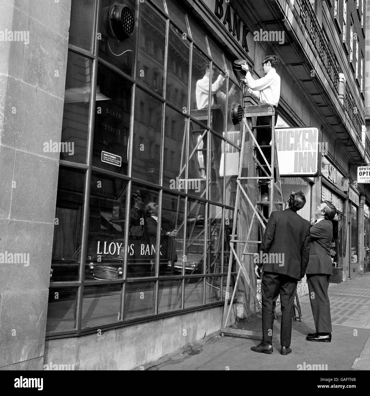 Police testing the alarm system at the Lloyd's Bank branch on the corner of Marylebone Road and Baker Street, where many thousands of pounds were believed stolen in a raid at the weekend. The raid was thought to be the one a radio 'ham' overheard two men discussing. Stock Photo
