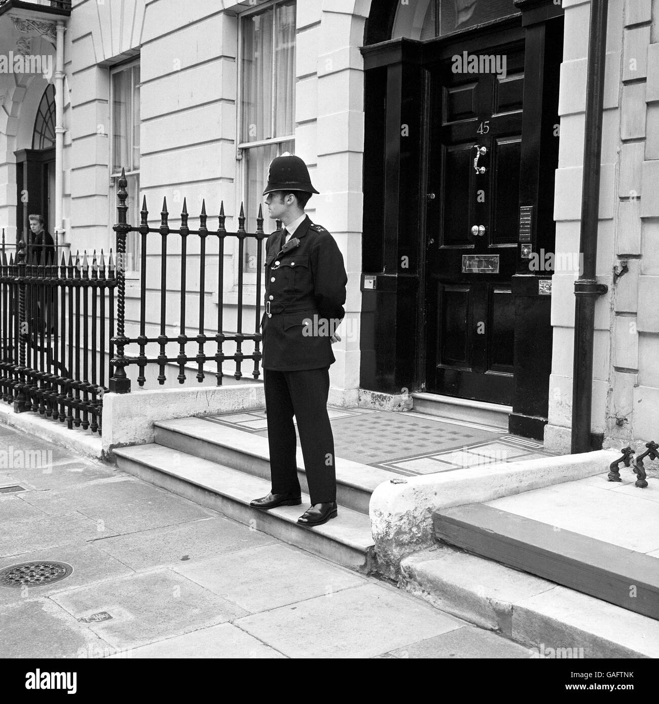 A policeman is seen on duty outside the block of flats in Wimpole Street, London today, where the radio 'ham' lives who tipped off police that he had overheard a gang talking about a raid. Later the police searched a number of banks within a 10 mile radius, including the branch of Lloyd's where a huge haul was carried out. Stock Photo