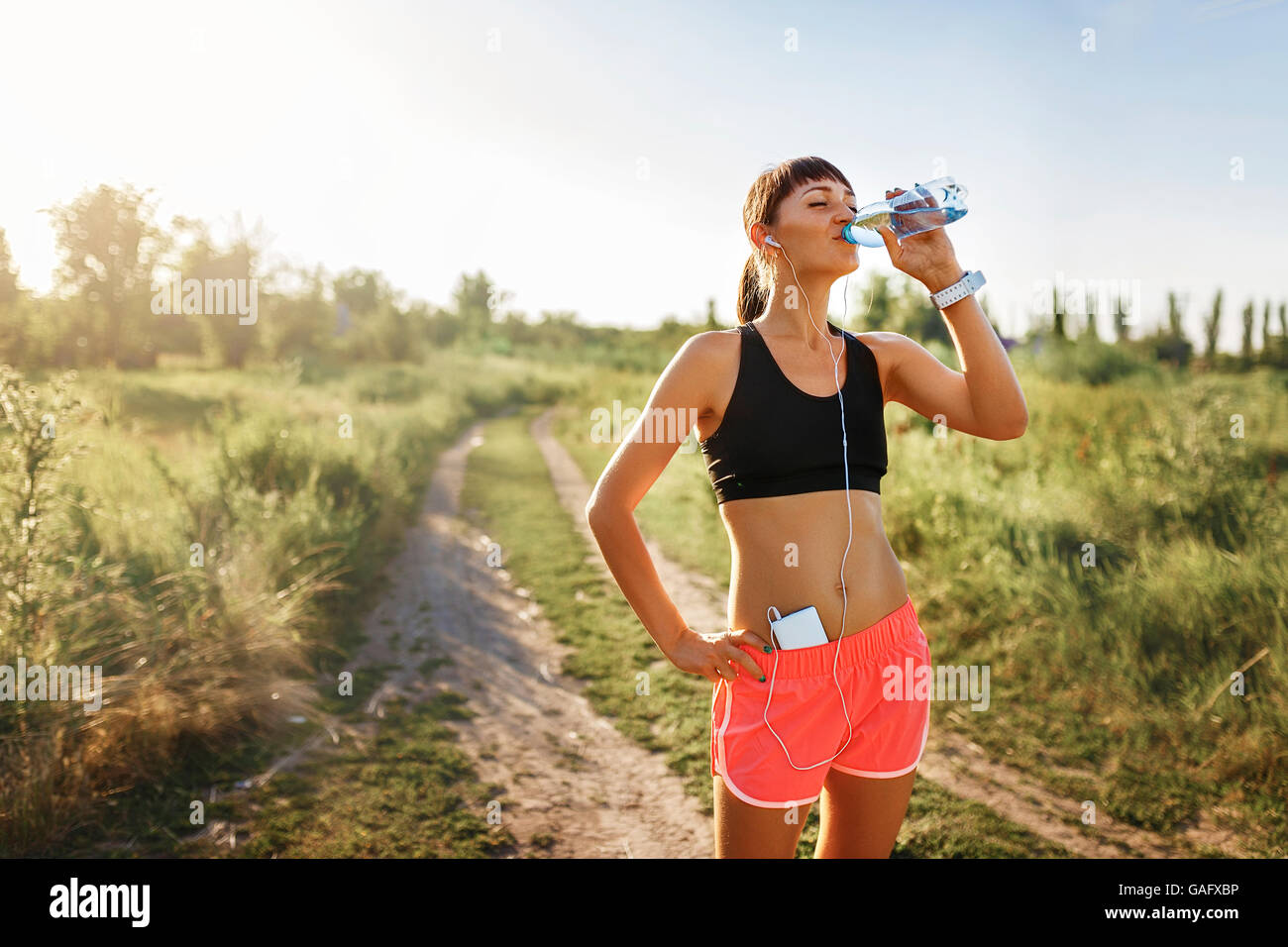 Форма для бега на улице. Влияние бега на организм. Энергетический гель для бега. Тренировки в жару. Спортсмен пьет воду.