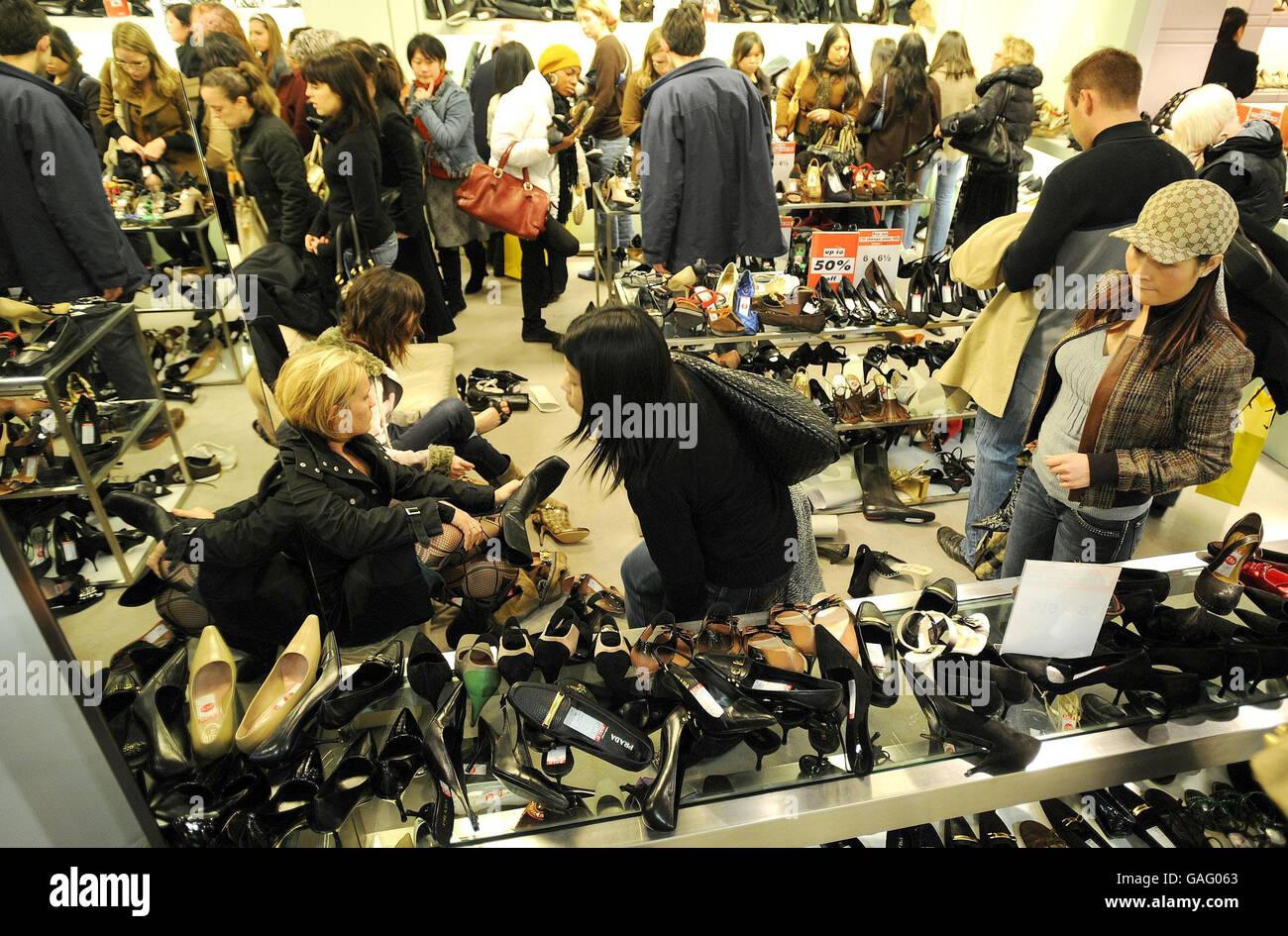 A crowd of shoppers look at shoes in Selfridge's Oxford Street store in