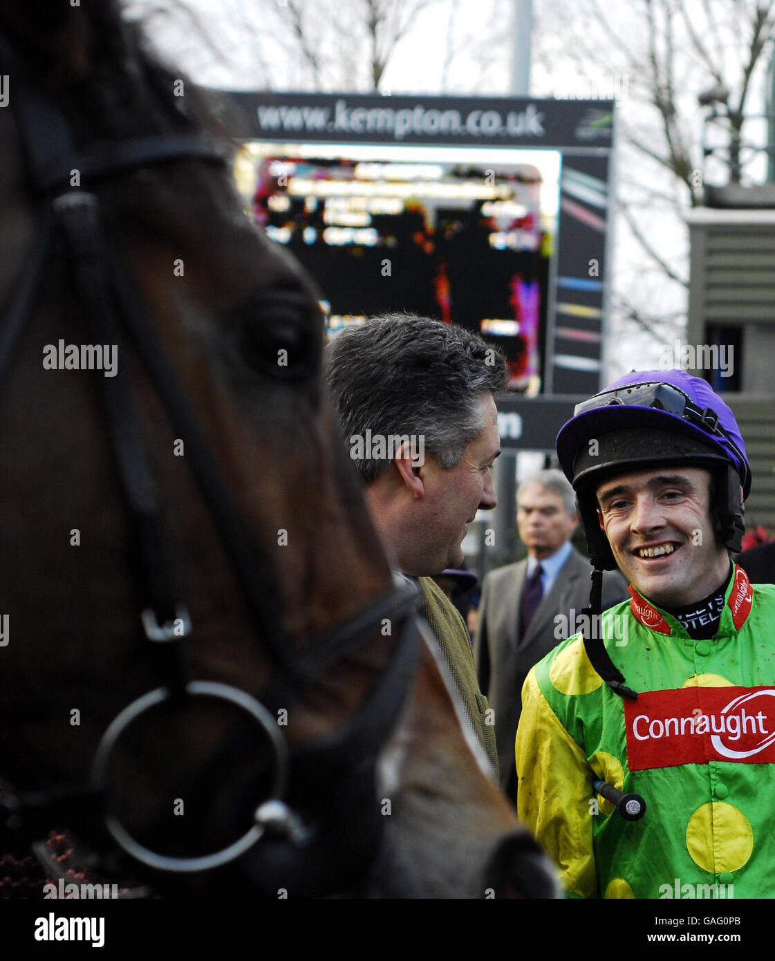 Kauto Star looks on as trainer Paul Nicholls talks to jockey Ruby Walsh after victory in The Stan James King Georg VI Chase at Kempton Park Racecourse. Stock Photo