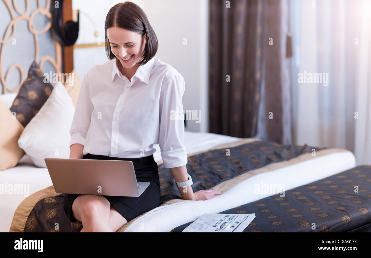 Positive beautiful smiling woman sitting on the bed Stock Photo - Alamy
