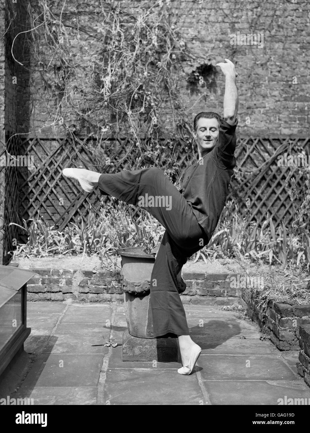 Ballet dancer Anton Dolin, flexing his muscles on the terrace of his London home, after flying back from Cannes, where he was beaten up and robbed. The beating up was received at the hands of a notorious Riviera bandit whom the French police had been hunting for two years. Dolin was able to identify him, leading to his arrest. Stock Photo