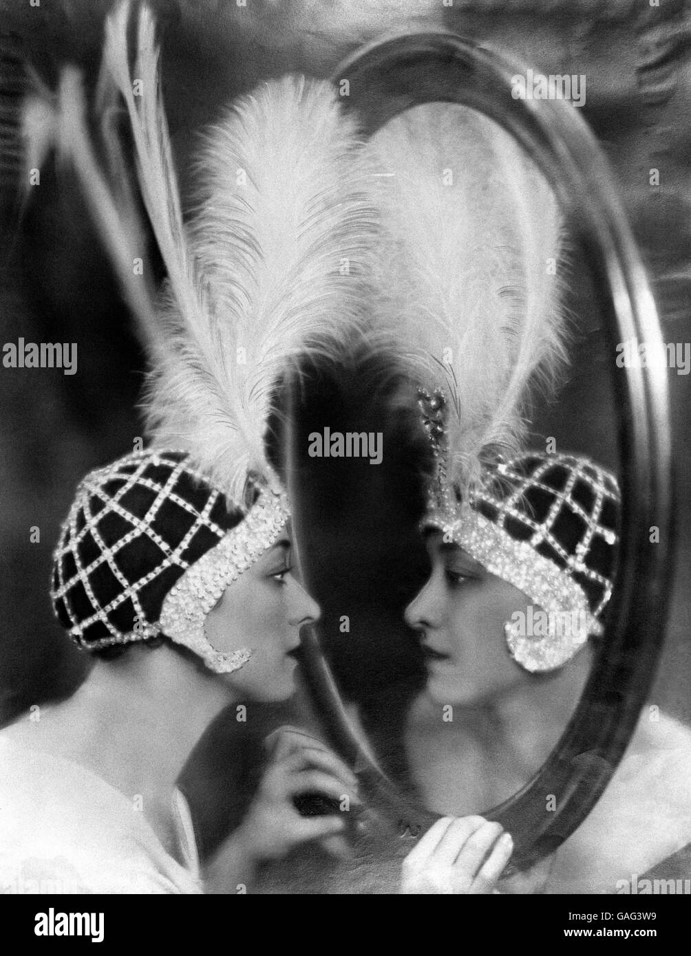 The Dolly Sisters - 1924. Rosie Dolly (l) appears to be looking in a mirror, but is actually looking at her twin sister, Jenny Dolly. Stock Photo