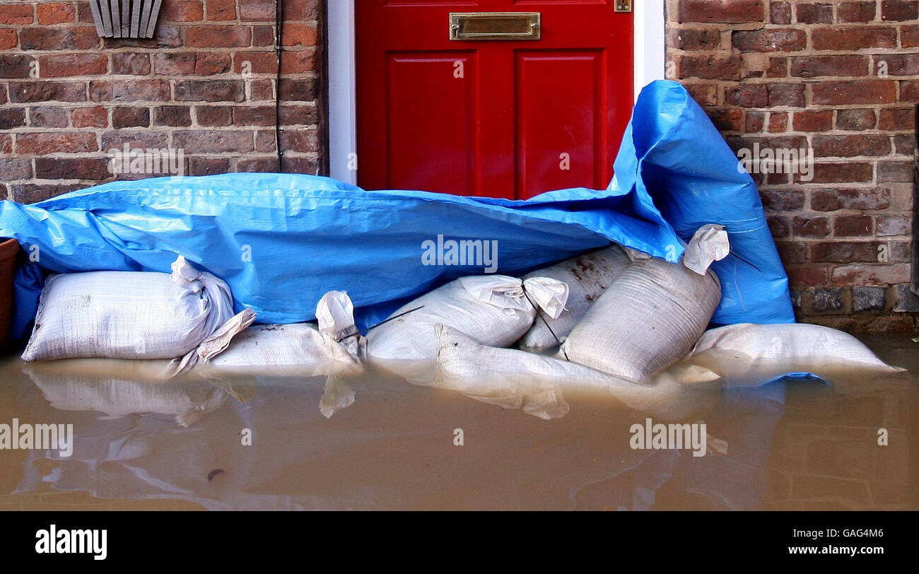 Continuing flooding in UK. Sand bags try to stop flood water entering a house on New Street in Upton on Severn, Worcestershire. Stock Photo