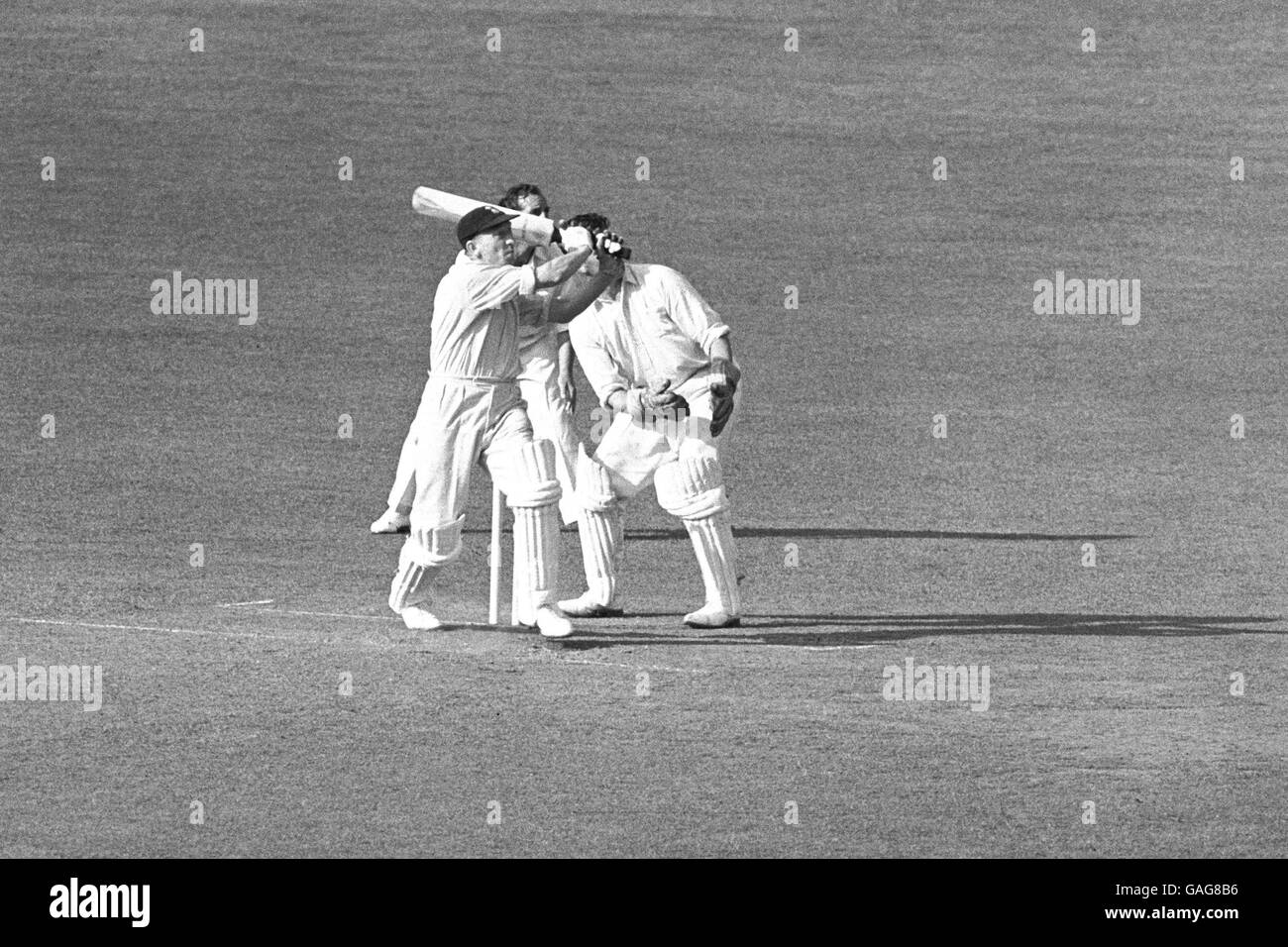 Surrey's Stuart Surridge (l) tries to smack the ball out of the ground, only to be caught on the boundary by Middlesex's Jack Robertson (out of picture) Stock Photo