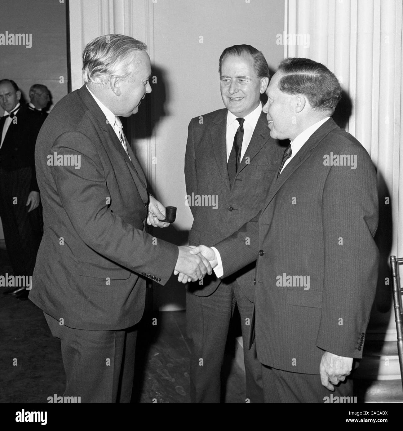 Harold Wilson greeted by Leslie Williams, Secretary General of the National Staff Side and Vice-Chairman of the National Whitley Council, at the Banqueting House, Whitehall, when the Prime Minister was a guest at a reception to celebrate the 50th anniversary of Whitley is (basis of staff-management relations) in the Civil Service. Centre is Sir William Armstrong, Head of the Home Civil Service and Chairman of the National Whitley Council. Stock Photo