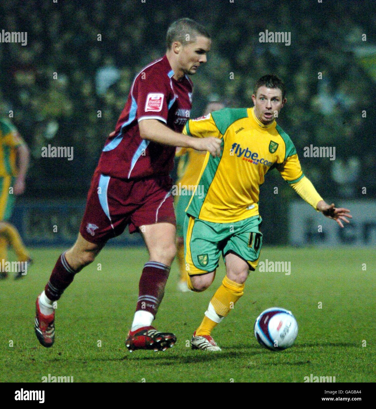 Scunthorpe's Jim Goodwin (left) and Norwich's Jamie Cureton in action during the Coca-Cola Football League Championship match at Glanford Park, Scunthorpe. Stock Photo