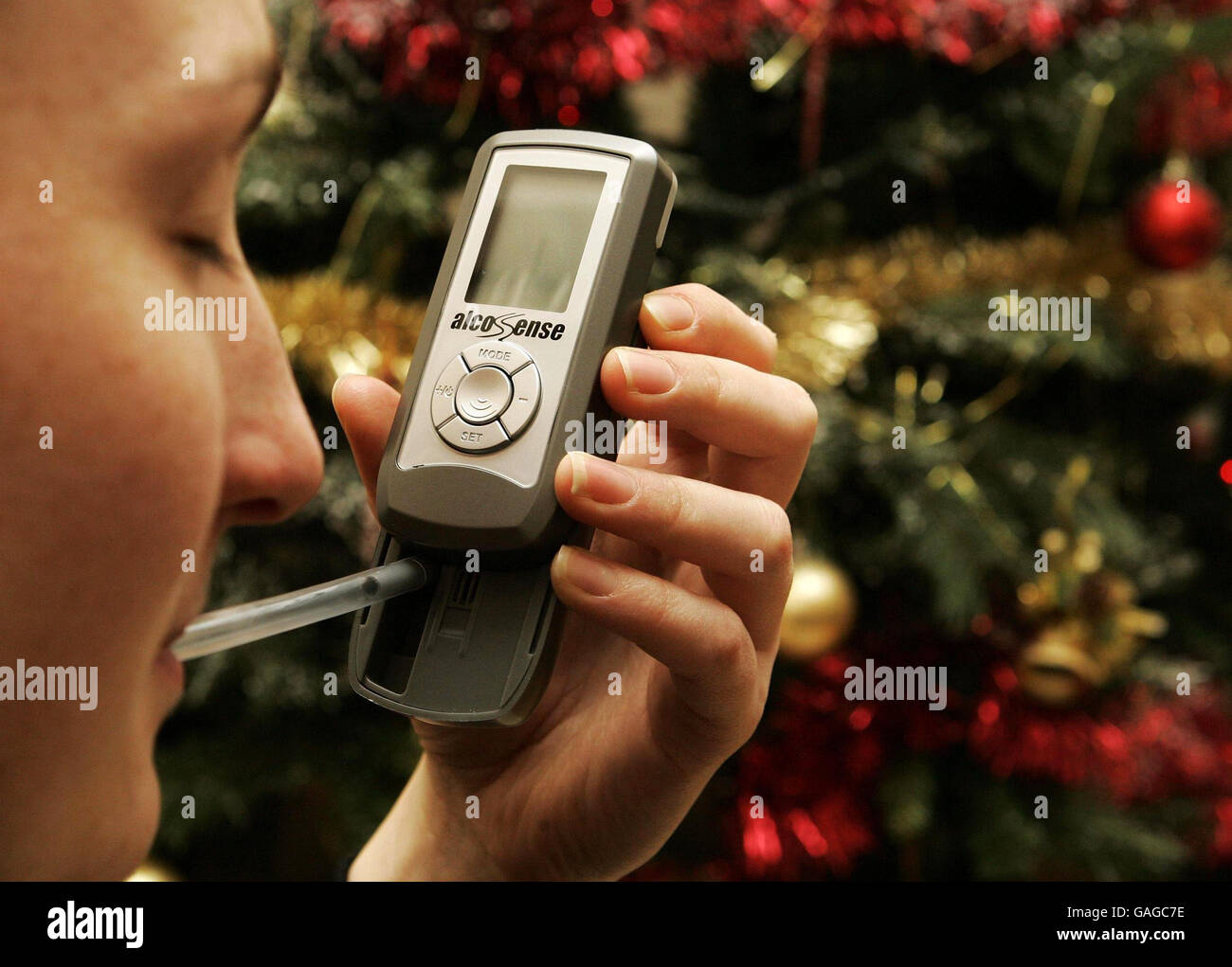 A person pictured using an Alcosense pocket Breathalyser, which can