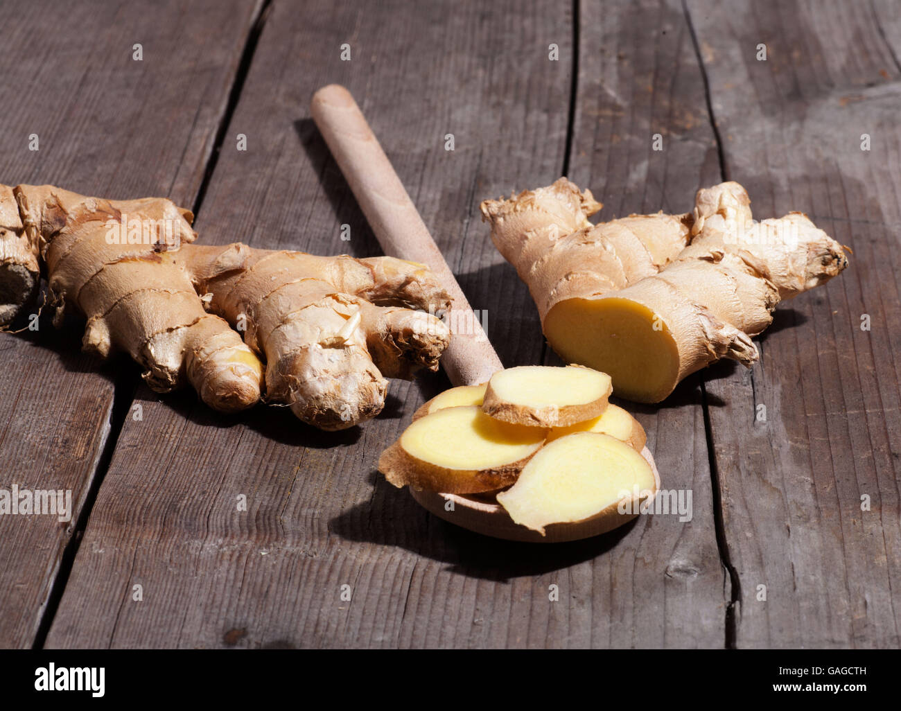 Ginger slices on wooden board Stock Photo