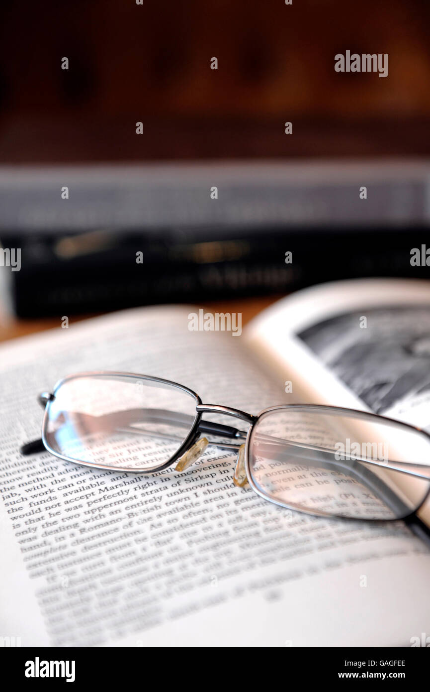 Reading glasses on top of book of antiquity Stock Photo