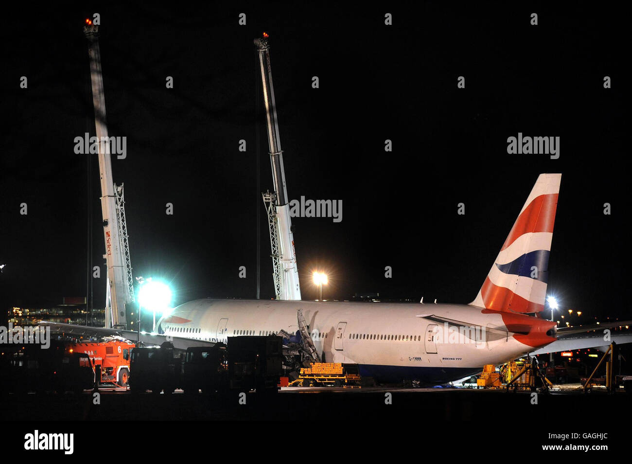The British Airways Boeing 777 plane that crash landed at Heathrow yesterday afternoon, is held up off the ground by two giant cranes, this evening. Stock Photo