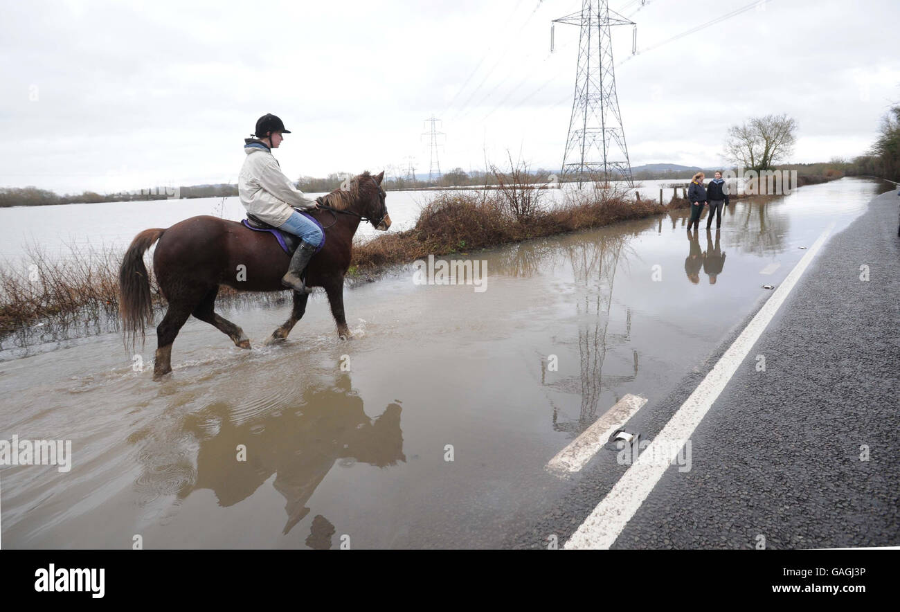 21 year-old Jennie Pallett from Gloucester on 'Saffron' enjoys a walk on the flooded A417 road at Maisemore near Gloucester. Stock Photo