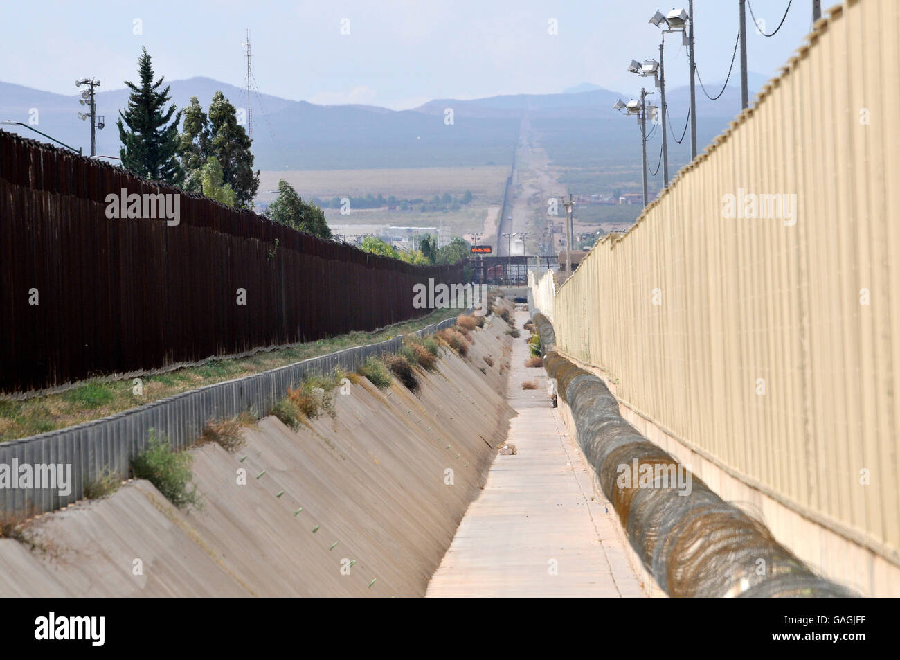 A culvert runs along the international border wall between Agua Prieta, Sonora, Mexico, and Douglas Arizona, USA, as seen from A Stock Photo