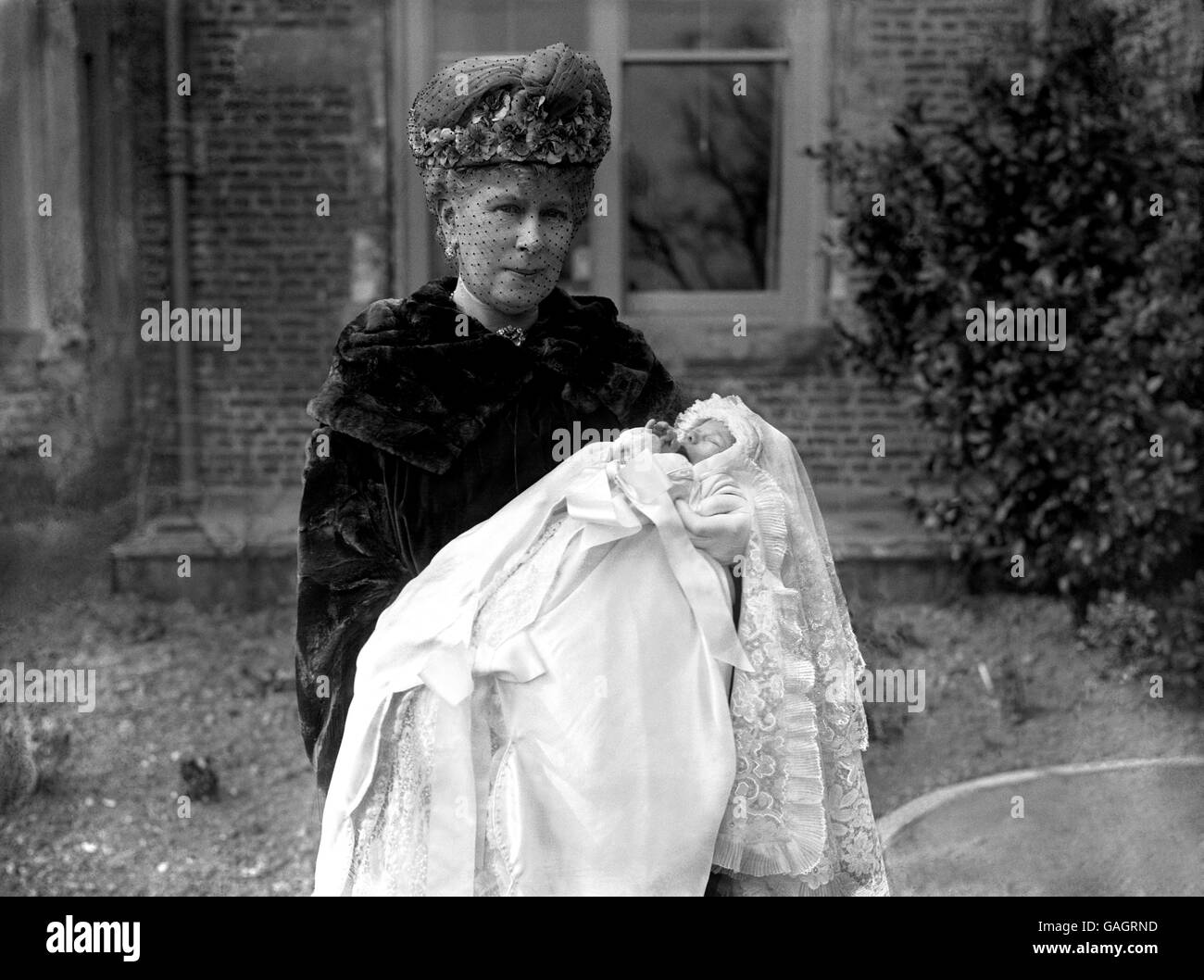 Queen Mary with her baby grandson, George Lascelles, later to be the 7th Earl of Harewood, the son of Mary, the Princess Royal, at his Christening in Goldborough Church, Yorkshire. Stock Photo
