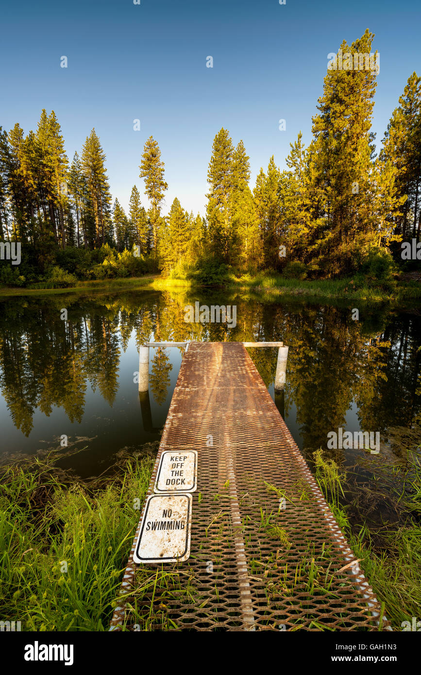 Pond in the Idaho mountains with a Doc with warning signs Stock Photo