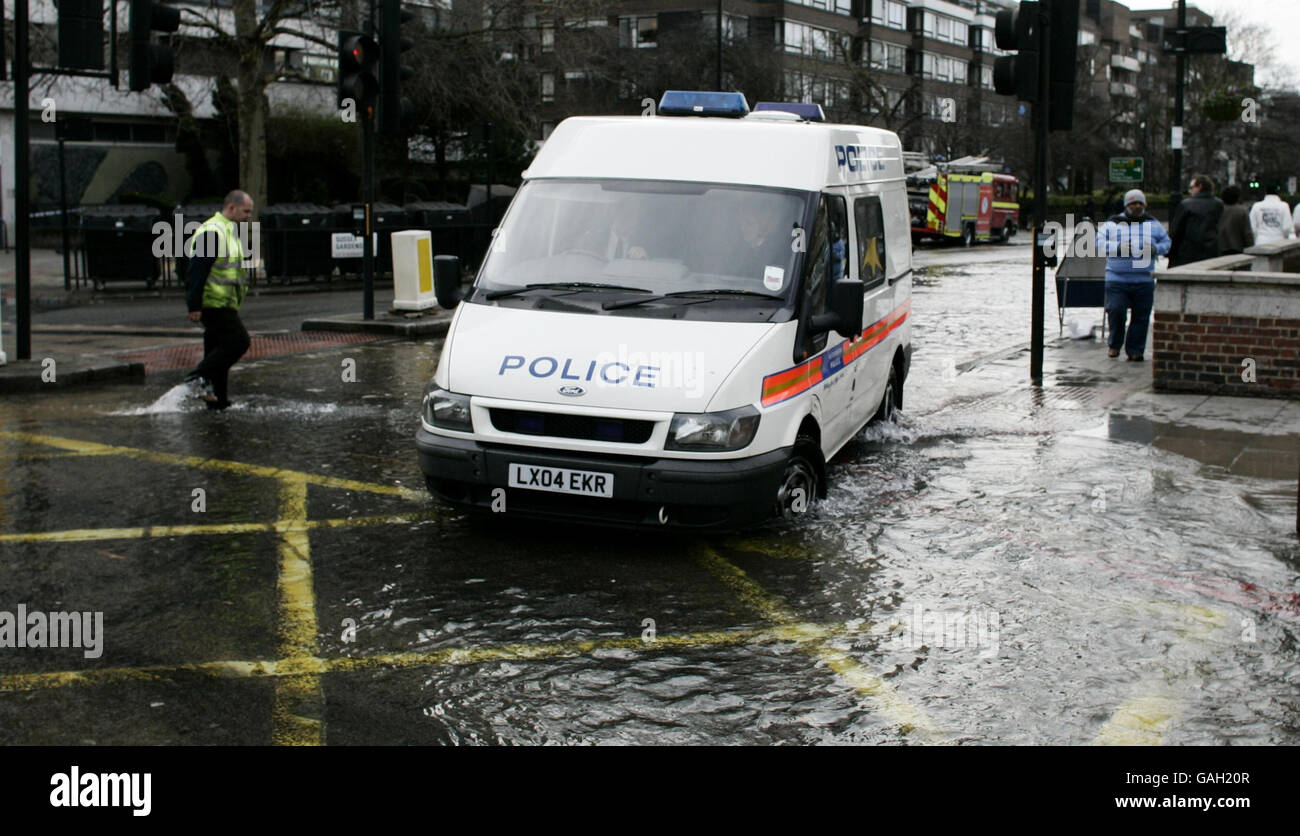Burst water main in London. A police van drives through water after a burst water main in Edgware Road, London. Stock Photo