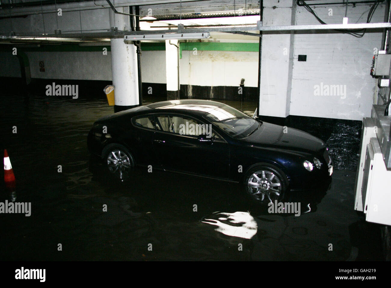 A Bentley GT Continental sits in water in Kendall Street Car Park after a water main burst in Edgware Road, London. Stock Photo