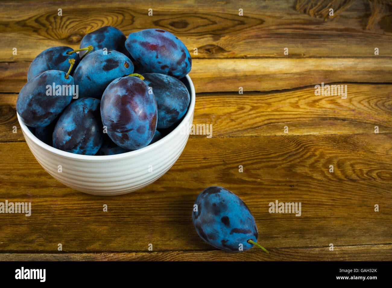 Fruit plum prunes in a white cup on a wooden table. Selective focus Stock Photo