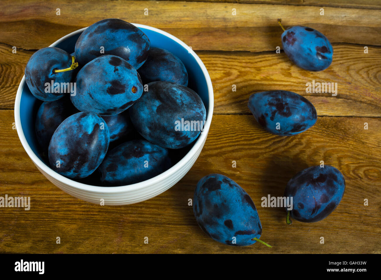 Fruit plum prunes in a white cup on a wooden table top view. Selective focus Stock Photo
