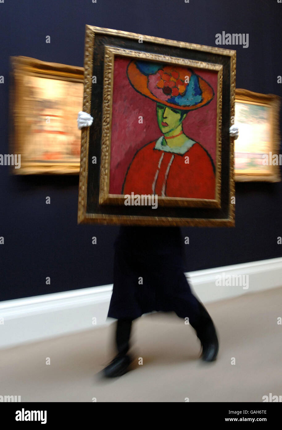 A porter at Sotheby's London auction house moves a portrait, Schokko