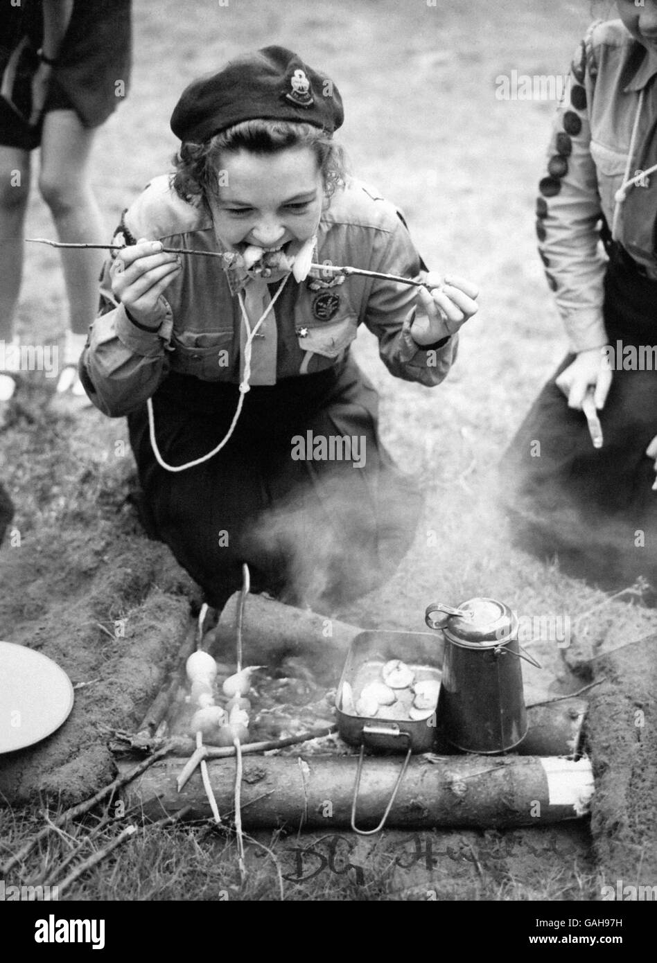 A thousand girl guides representing 40 nationalities are at the first camp to take place in Britain since 1924. Catherine Douglas approaches, with cautious relish, a meal cooked on sticks. Stock Photo