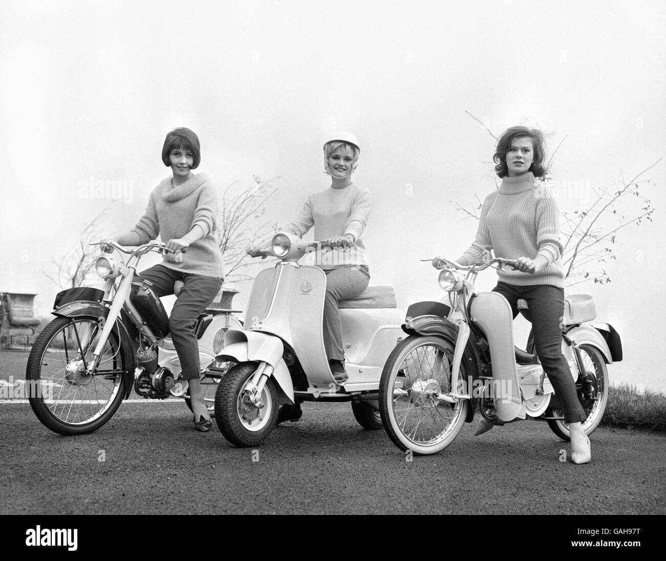 Two new mopeds and a new scooter produced by Raleigh of Britain are displayed for the Motorcycle and Cycle Show at Earls Court, London. (L-R) Cynthia Cassidy, on the Automatic, Sally Foot, on the Roma, and Vicky Ward, on the Supermatic. Stock Photo