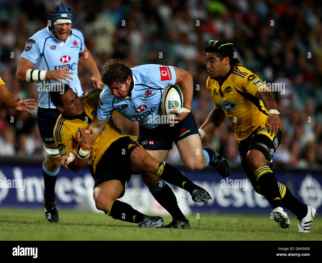 Waratahs Matt Dunning is tackled by Hurricanes Chris Masoe during opening match of the Super 14's season for the NSW Warartahs and New Zealand Hurricanes Stock Photo