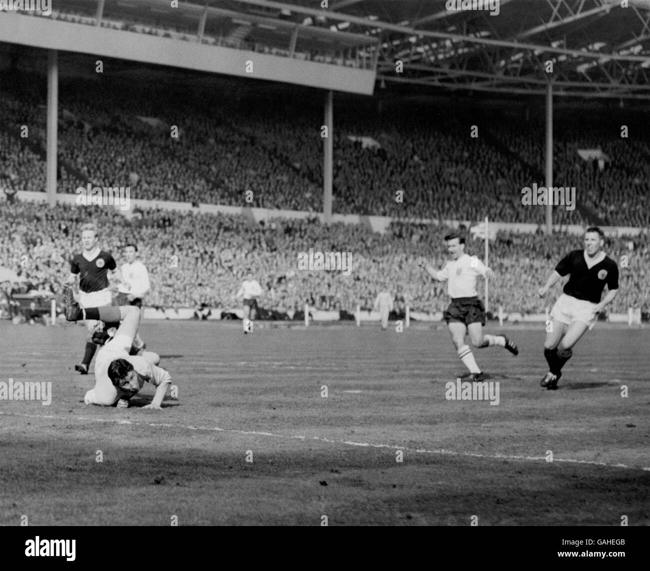 England's Bryan Douglas (second r) fires his team's only goal past Scotland goalkeeper Bill Brown (diving), watched by Scotland's Alex Hamilton (r) and Davie Wilson (l) Stock Photo