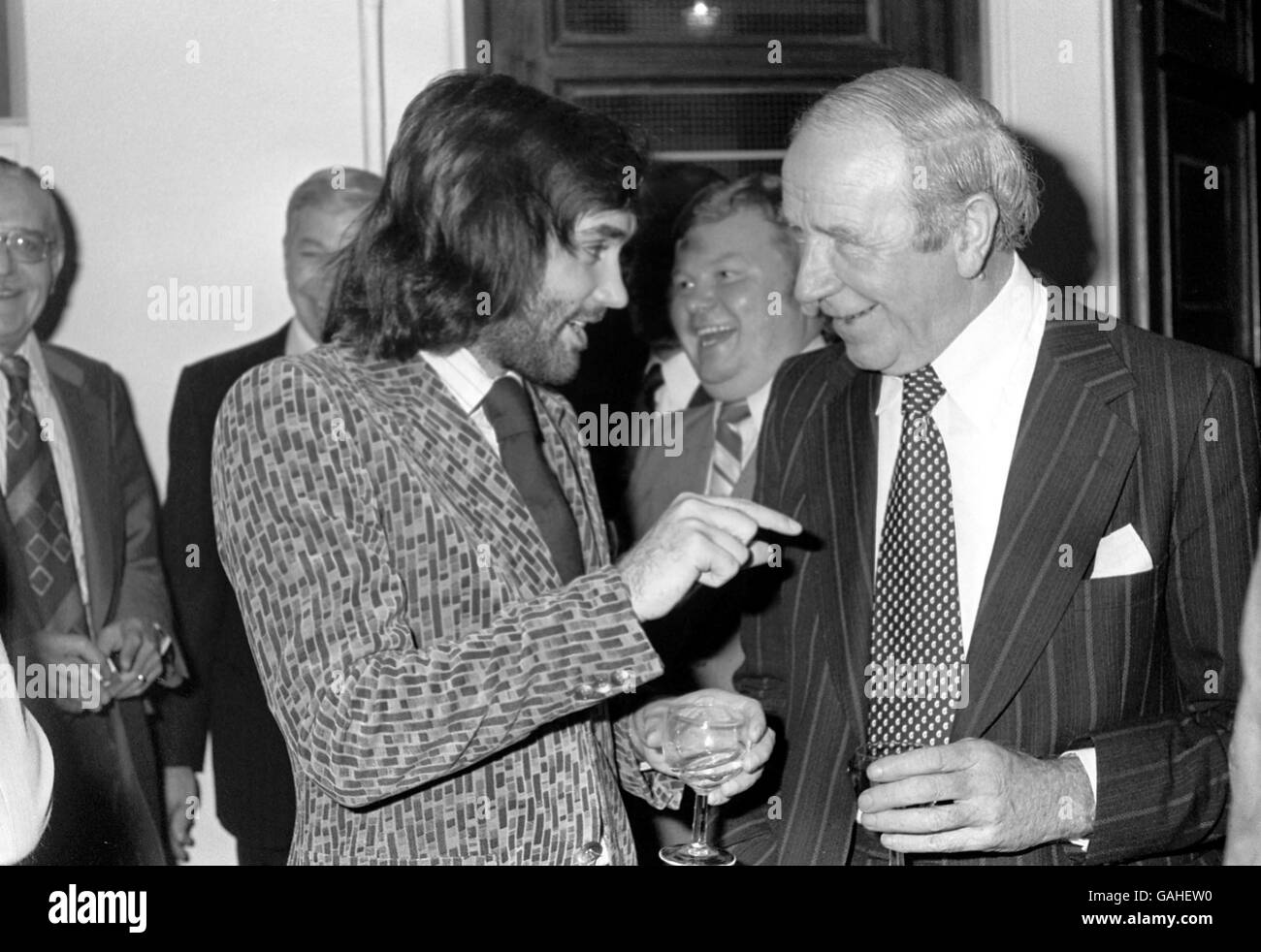 Fulham's George Best (l) chats with his mentor, Sir Matt Busby (r), as Benny Hill (c) has a laugh in the background Stock Photo