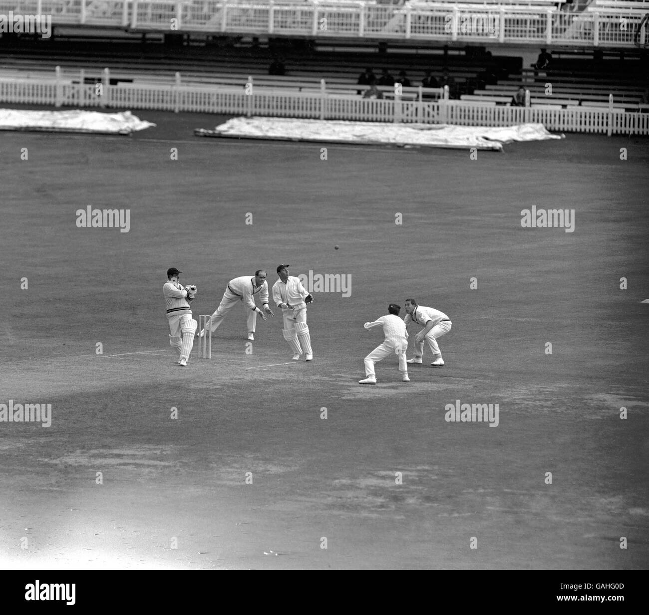 (L-R) India's Chandu Borde dollies the ball into the slips, watched by MCC's Brian Close, wicketkeeper John Murray, Mike Denness and John Hampshire Stock Photo