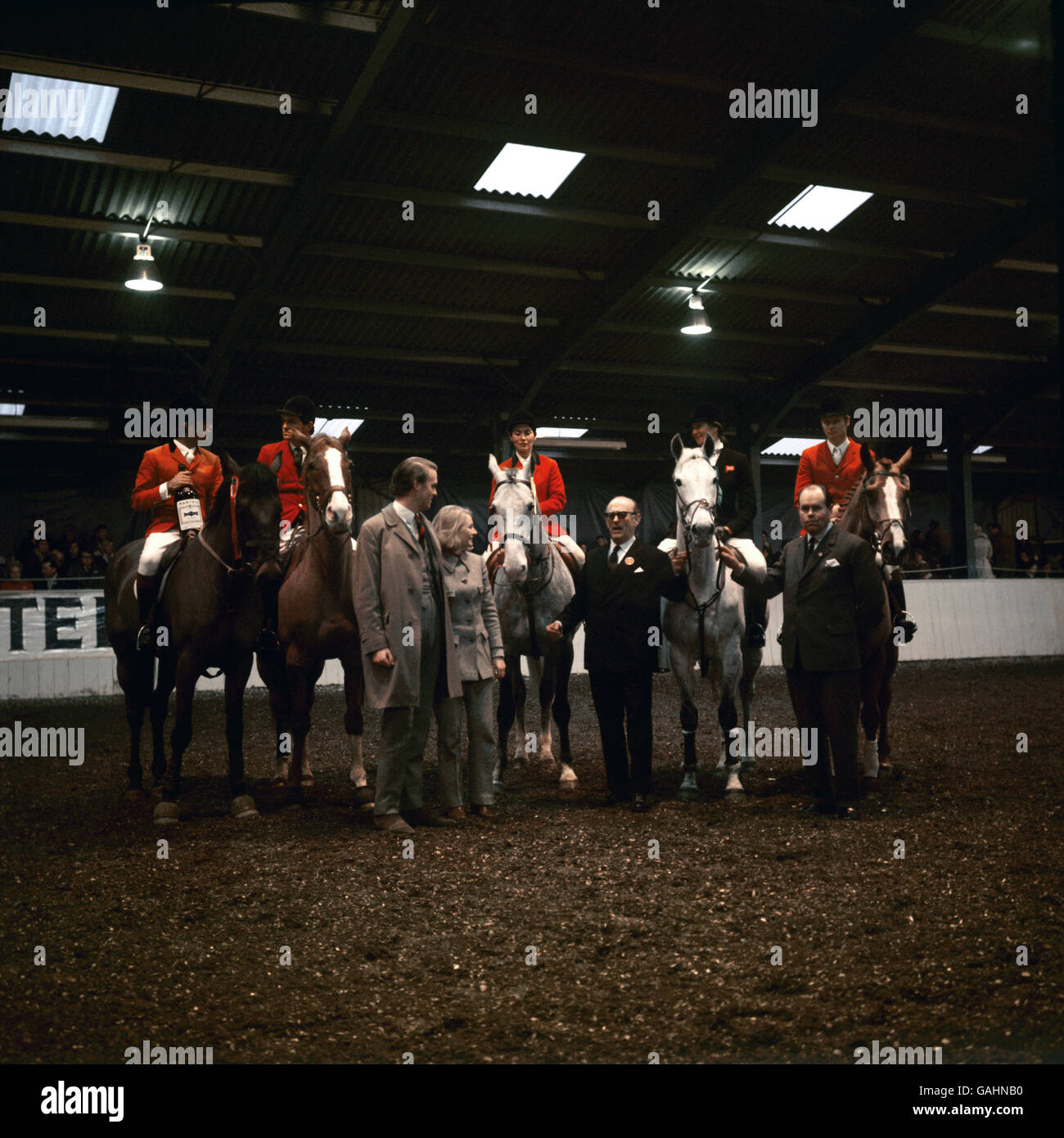 Left to right on horseback: Nelson Pessoa of Brazil, with the half gallon of Brandy, Harvey Smith, Janou Lefebere, Anneli Drummond-Hay and Hermann Shridde, Standing Left to right: Mr and Mrs S. Gordon Clark (of the Martell Shippers) and judges Lt. Colonel Harry Llewellyn and Geoffrey Banham after the Martell Internatioinal Jumping Event. Stock Photo