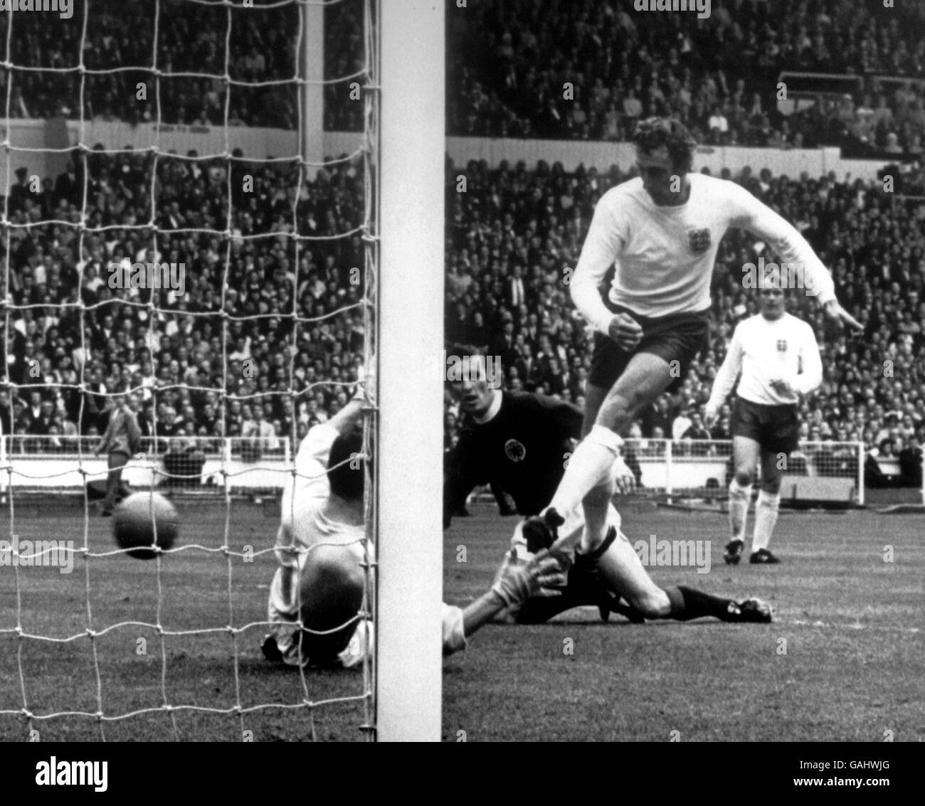 Scotland's Jim Brogan (c) looks on as England's Martin Chivers (r) flips the ball past Scotland goalkeeper Ronnie Simpson (l), only for the goal to be disallowed Stock Photo