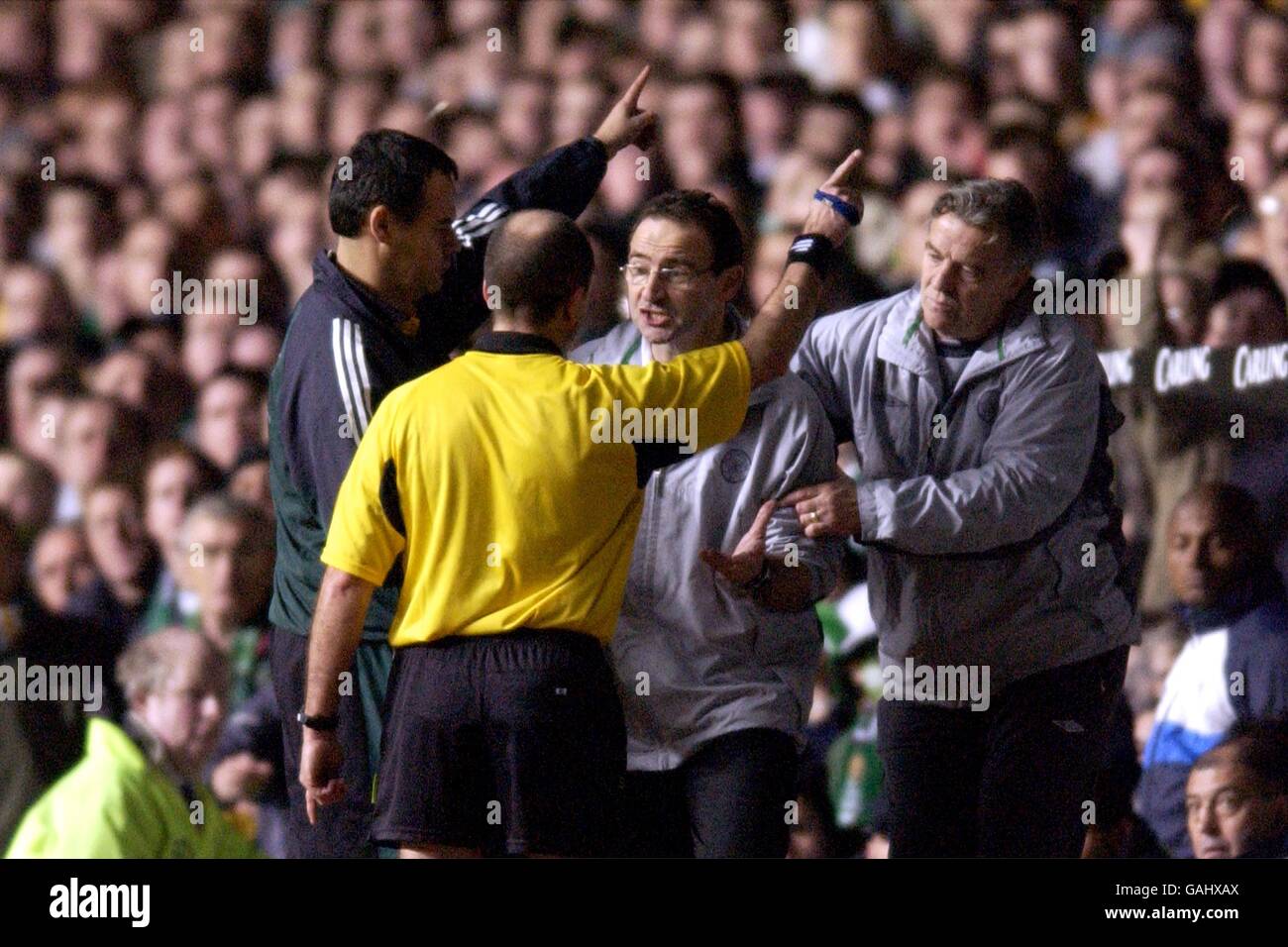 Martin O'Neill the Celtic manager gets sent off by fourth official Bruno Derriem and referee Claude Colunbo with assistant manager John Robertson Stock Photo