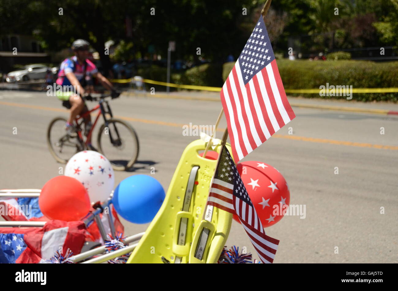 A bicyclist rides past a decorated bicycle after the Fourth of July parade in Ross, California in Marin County. Stock Photo