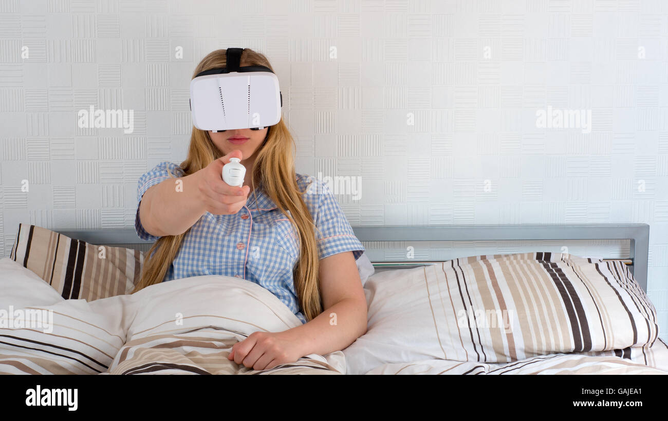 Beautiful woman using VR headset in bed Stock Photo Alamy