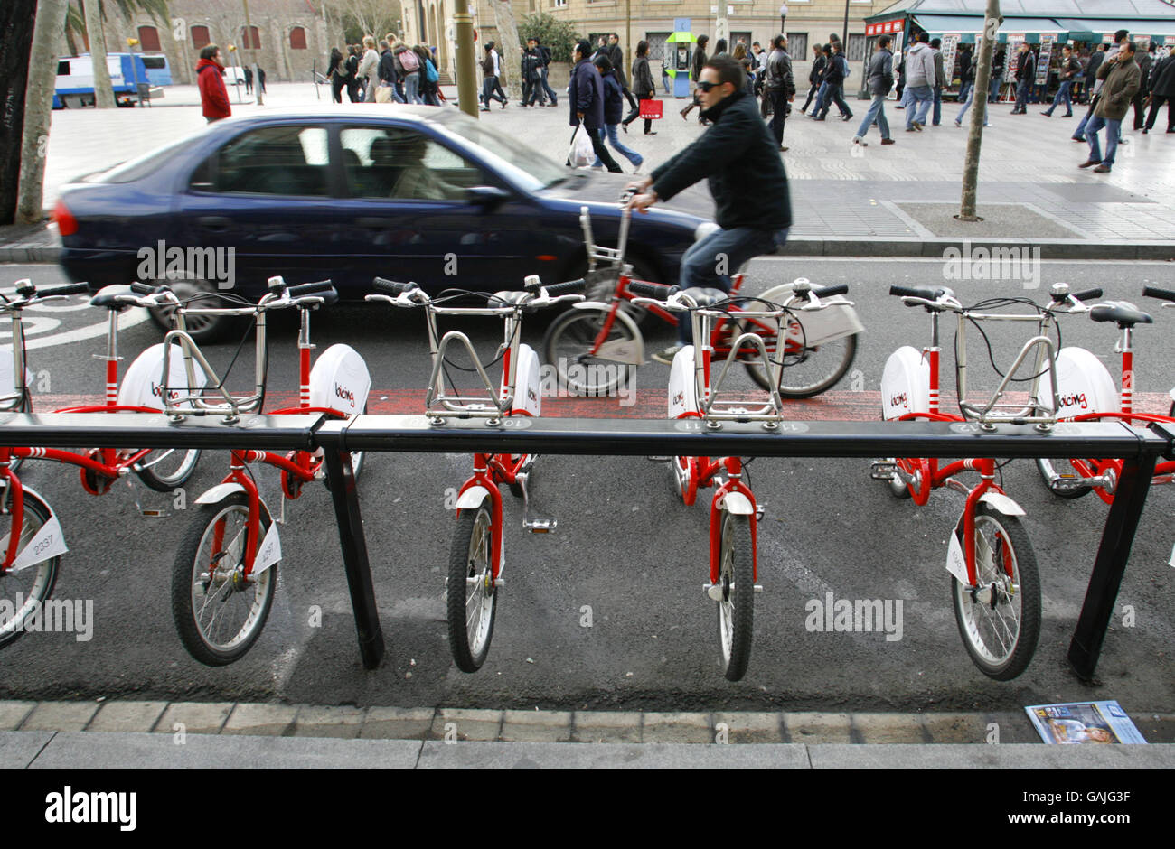 People in Barcelona, Spain using hired bicycles to get about the city. The new scheme called Bicing enables registered users to take a cycle from any of the 100 automated stations in the Catalan capital and make a journey of up to two hours before returning it to any other station. The bikes' front baskets are locked to a rail which releases when an electronic card is placed against the machine consul. The system is promoted as an extra form of public transport and costs just 0.3 euros per 30 minutes plus an annual charge of 24 euros. Stock Photo