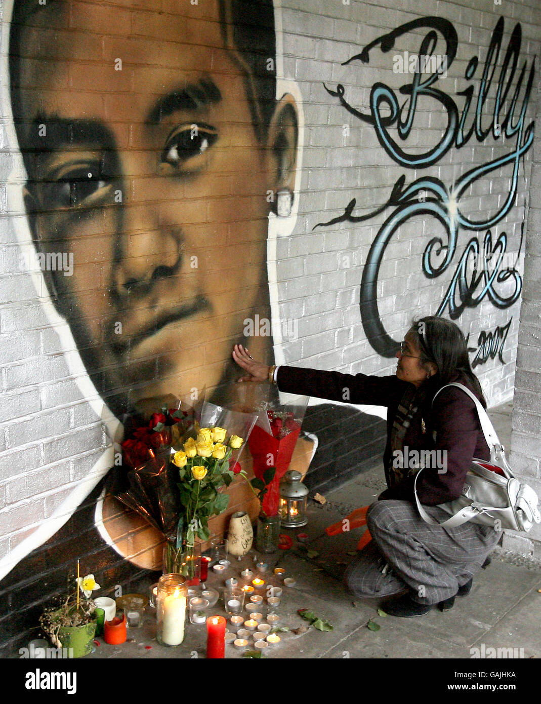 Tim, the mother of murdered teenager Billy Cox, touches the mural where he died in Clapham on the first anniversary of his death. Stock Photo