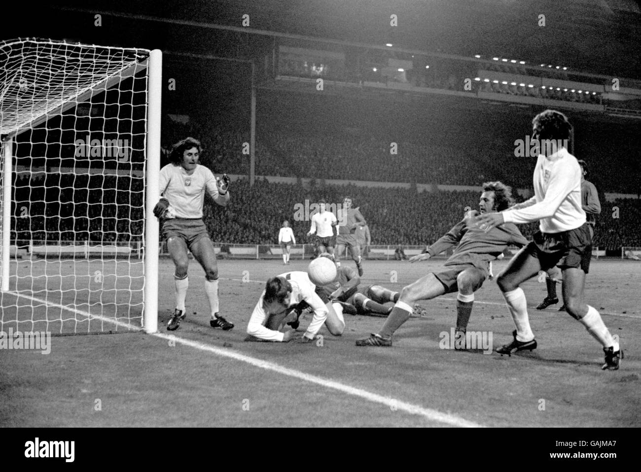 Poland goalkeeper Jan Tomaszewski (l) covers his near post as England's Allan Clarke (on floor) and Martin Chivers (r) try to force the ball in Stock Photo