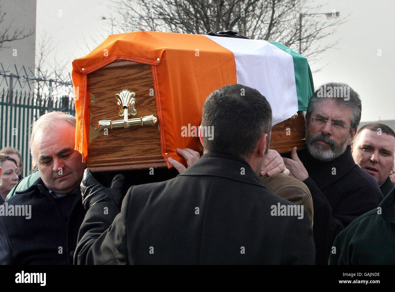 Sinn Fein president Gerry Adams (right) carries the coffin of a former IRA hunger striker, Brendan Hughes, in west Belfast. Stock Photo