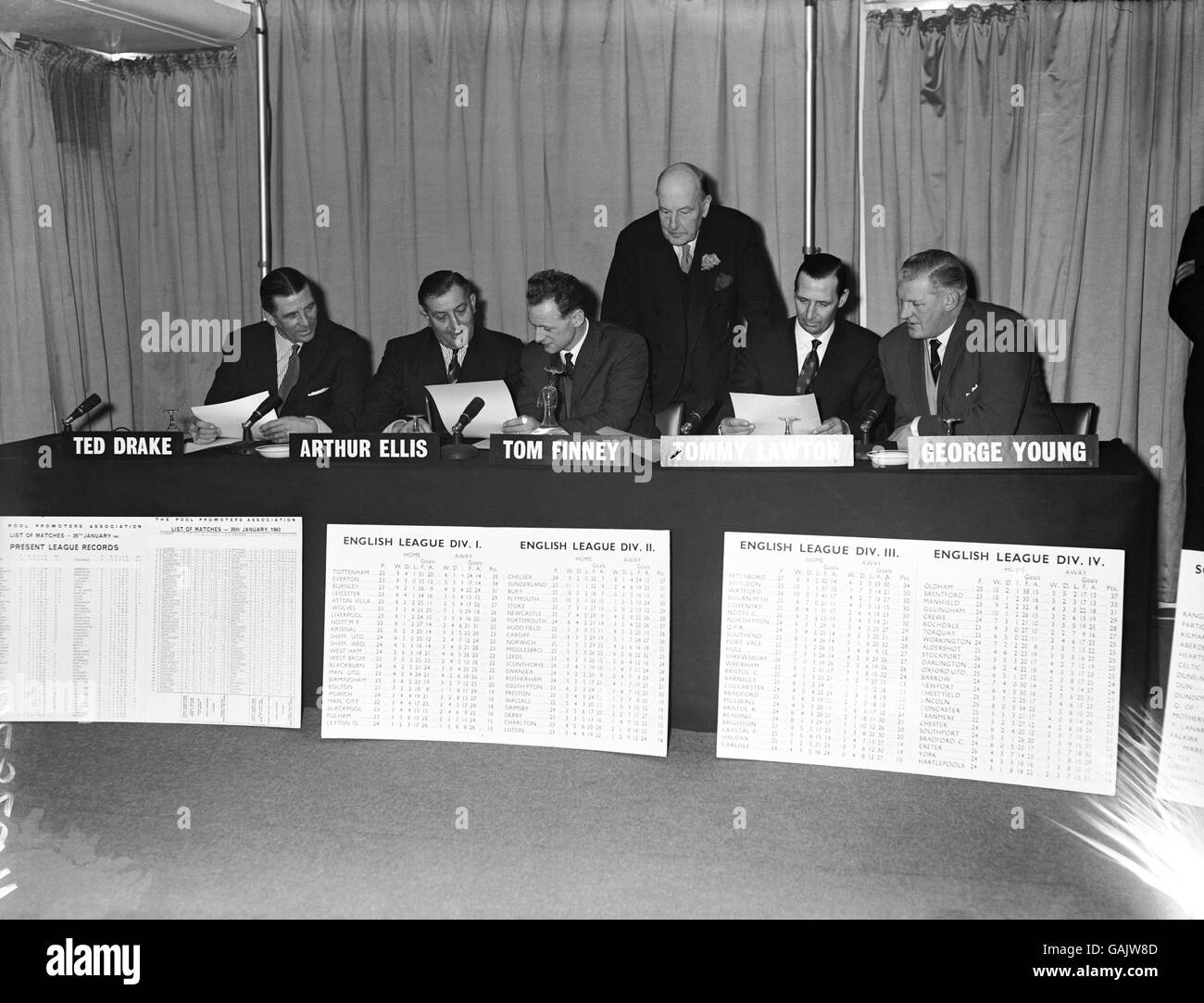 The Chairman of the Pools Selection Board, Lord Brabazon (third r), looks on as his fellow board members, (l-r) Ted Drake, Arthur Ellis, Tom Finney, Tommy Lawton and George Young, predict results for the weekend matches cancelled due to the Big Freeze Stock Photo