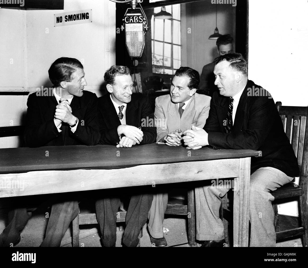 Preston North End and England's Tom Finney (second l) takes part in a radio discussion at the Central African Broadcasting Station concerning the relative standards of the game in England and Northern Rhodesia. His interlocutors are (l-r) John Burgess (former Pegasus player), Donald Lightfoot (producer of the programme) and Bob Hesford (former Huddersfield Town goalkeeper who opposed Finney in the 1938 FA Cup Final) Stock Photo
